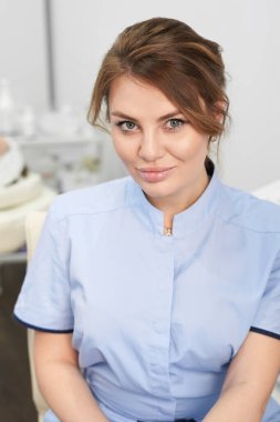 Güzellik ofisinin arka planında başarılı genç bir kozmetik uzmanı. Süslü güzellik uzmanının portresi