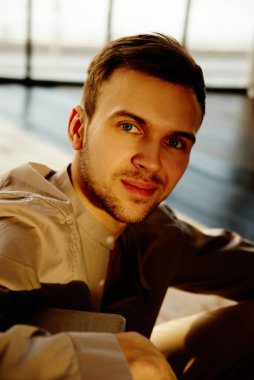 Yakışıklı, başarılı, sağlıklı, beyaz bir adamın yakın plan portresi kameraya bakar.