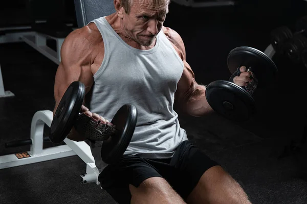 Homem Brutal Adulto Muscular Com Halteres Bombeia Bíceps Ginásio Retrato — Fotografia de Stock