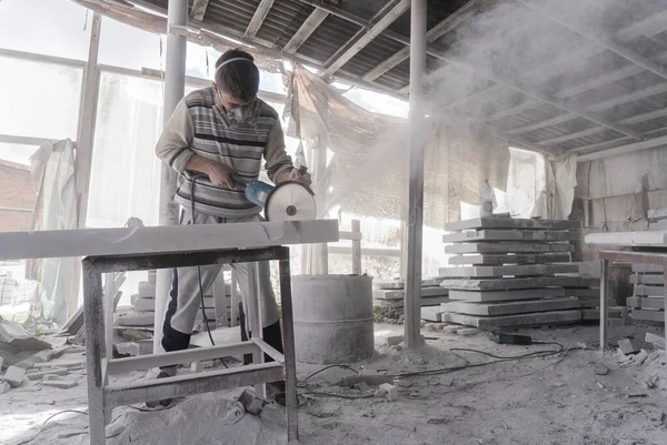 The master engraves the tombstone. Stone processing