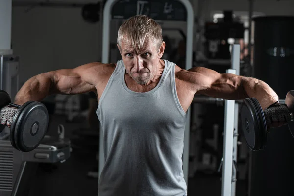 Homem Brutal Adulto Muscular Com Halteres Bombeia Bíceps Ginásio Retrato — Fotografia de Stock