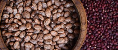 Pinto fasulye kırmızı fasulye arka plan üzerinde ahşap kase