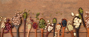 Meşe ağacından arka planda tahtadan kaşık içinde fasulye ve mercimek çeşitleri.