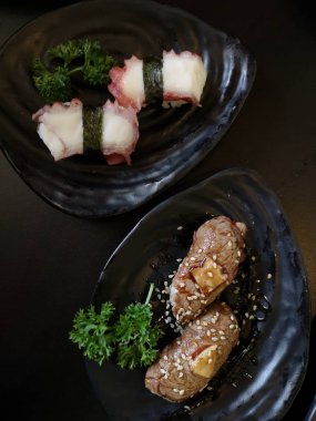 Seramik tabakta taze suşi ve Japon yemeği.