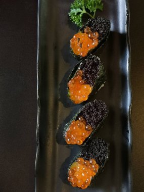 Seramik tabakta taze suşi ve Japon yemeği.