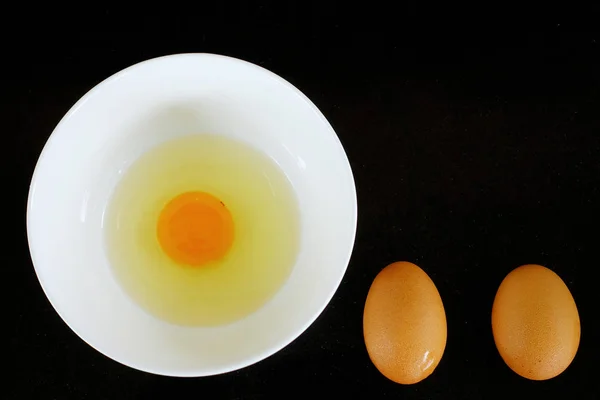 Top view of eggs in bowl on black background