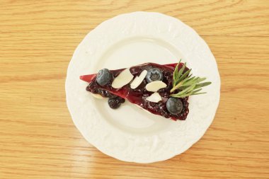 Beyaz tabakta yaban mersini cheesecake bir parça üst görünümü