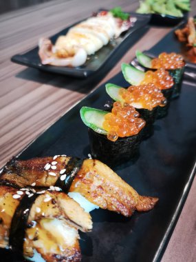 Seramik tabakta taze suşi ve Japon yemeği.