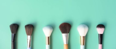 Yeşil arka planda makyaj fırçaları seti