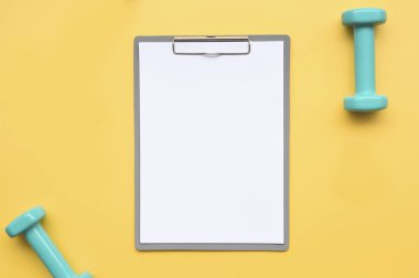 sarı arka planda boş kağıt ve halter