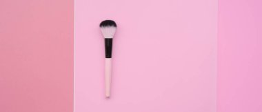 Pembe arka planda makyaj fırçaları