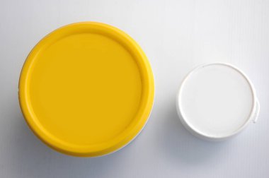 Beyaz arkaplanda izole edilmiş sarı ve beyaz plastik kapağın üst görünümü