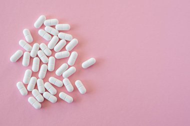 Pembe arka planda çok fazla ilaç var. Sağlık sigortası konsepti. Metin için boşluk.