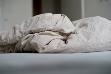 Modern bir yatak odasında çarşaf ve yastıkla yapılmamış yatak. Pis temizlik, yatak temizliği. Yüksek kalite fotoğraf