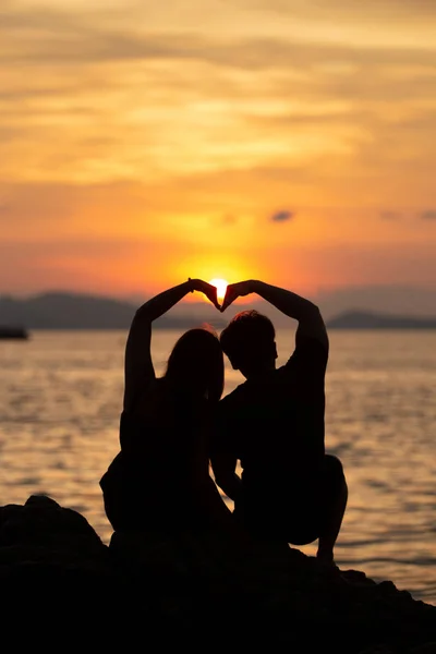 Ζευγάρι Κάνει Σχήμα Καρδιάς Στην Παραλία Στο Ηλιοβασίλεμα — Φωτογραφία Αρχείου