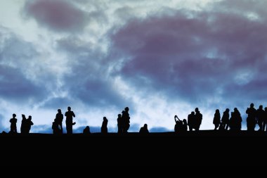 Silhouette image of group of unidentified tourists on sunset tim