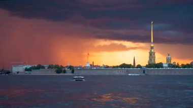 Gün batımında bulutlar Neva üzerinde gökyüzünü kaplar. Aziz Petersburg şehrindeki Peter ve Paul Kalesi 'nin güzel manzarası
