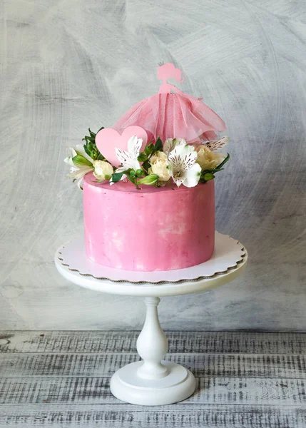 Pink cream cake for a baby girl with princess topper — Stock Photo, Image