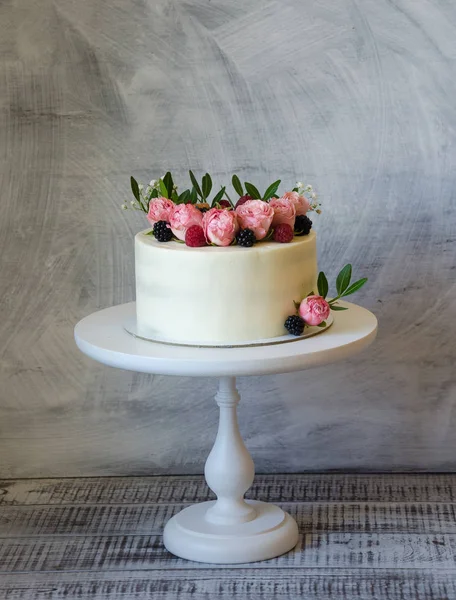 Cream cheese wedding cake with cupcakes decorated with berries a — Stock Photo, Image
