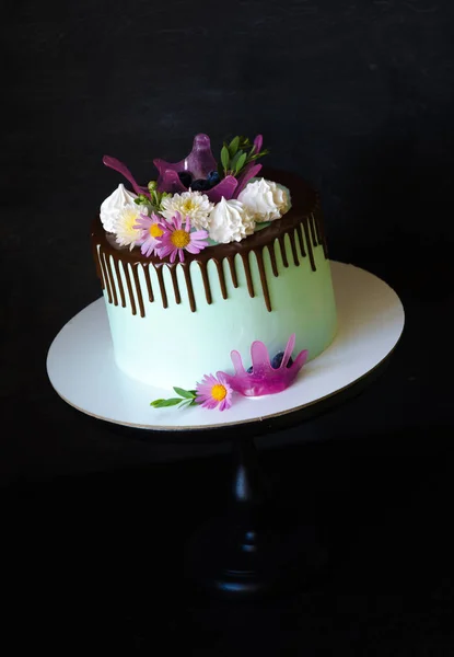 tasty chocolate drip cake decorated with zephyr and flowers