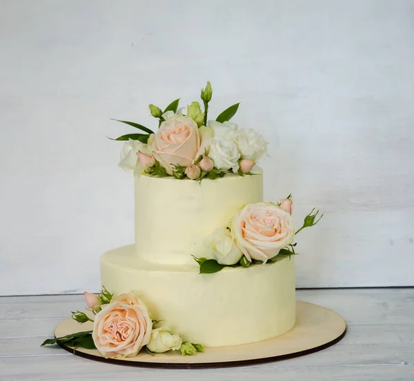 Gâteau de mariage décoré de roses et d'autres verdure — Photo