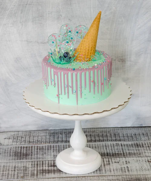 blue cake with ice cream cone and caramel decoration