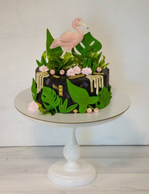 Flamingo ve tropikal yapraklı siyah kremalı pasta.
