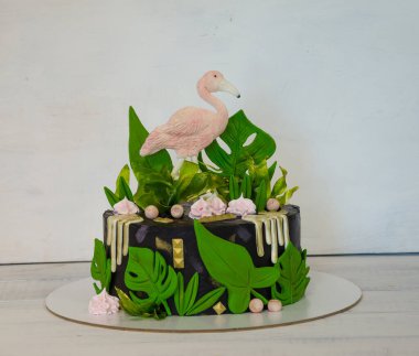 Flamingo ve tropikal yapraklı siyah kremalı pasta.