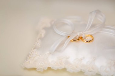 İzole edilmiş alyanslar beyaz bir yastıkta duruyor.