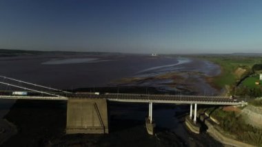 Parça yana doğru doğuya bakıyor Severn Köprüsü yayılımı boyunca dron. Bir güzel bahar akşamı alınan