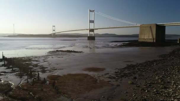 Drone Tracks Laag Zijwaarts Rivieroever Met Severn Bridge Achter Genomen — Stockvideo