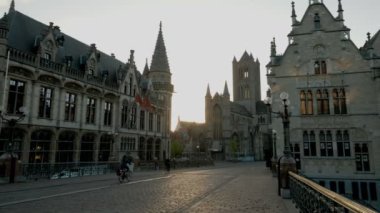 Statik görünüm Ghent eski şehir ve bisikletçiler olarak St Michael's Köprüsü'nden kilise. Bir bahar döneminde alınan sabah twilight