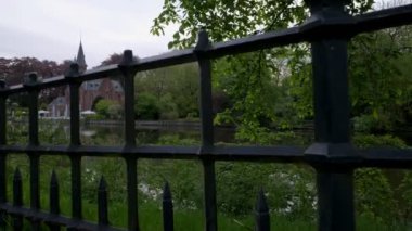 Kamera yükselir jib stil parmaklıklar Minnewater ve Brugge, Belçika Kasteel sakin bahar sabahı ortaya çıkarmak için geçmiş. 