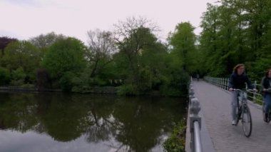 Minnewater, Brugge, Belçika bir sakin bahar sabahı için Kamera tava gelen Minnewaterbrug. Bisikletçiler köprüyü geçtikten
