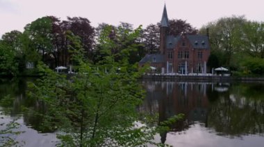 Kamera Minnewater ve Brugge, Belçika Kasteel sakin bahar sabahı ortaya çıkarmak için ağaç geçmiş slaytlar. 