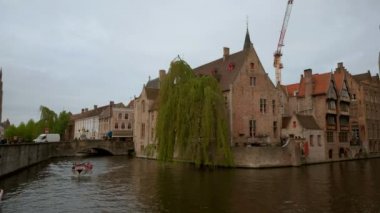 Kamera tava ile bir tur Katelijnestraat kanal çan kulesi Bruges, Belçika için tekne. Bir bulutlu bahar gününde alınan