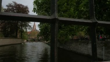 Katelijnestraat kanal, kuğu ve sivri, kilise, Meryem Bruges Brugge Belçika ortaya çıkarmak için parmaklıklar arkasında kamera yükselir