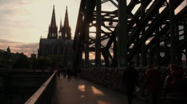 Yayalar güneş batmadan olarak Hohenzollernbrucke Köln Katedrali Almanya'ya karşı karşıya. 