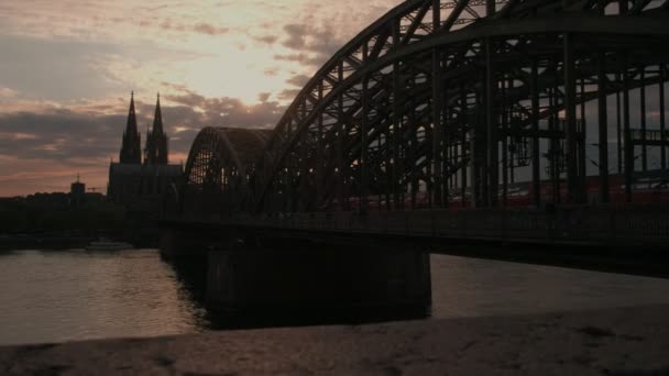 照相机幻灯片沿墙壁与 Hohenzollernbrucke 和科隆大教堂在日落 — 图库视频影像