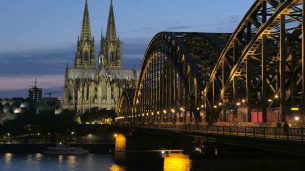 Statische Aufnahme der Hohenzollernbrücke und des Kölner Doms bei Nacht mit eingeschaltetem Licht. aufgenommen zur blauen Stunde