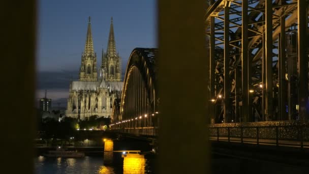 照相机上升到 Hohenzollernbrucke 和科隆大教堂在晚上以灯 在蓝色小时被采取火车十字架 — 图库视频影像