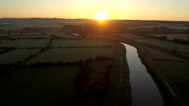 ドローンが英語風景を日の出を川アルン西のサセックスの上に戻って飛ぶ — ストック動画