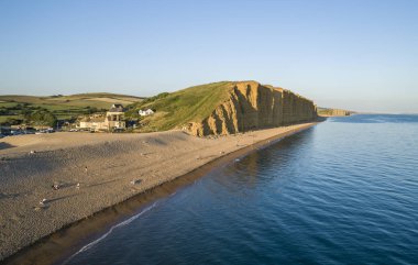 Sıcak plaj ve West Bay Dorset kayalıklardan alacakaranlık sırasında dron görüntü.