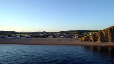 Dron yana doğru uçar ve kayalıklarla ve beach West Bay Dorset'deki / daki yanında yükselir. Altın saat sırasında vurdu. 