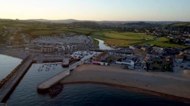 Bridport Dorset kırsal arka planda ile West Bay plaj üzerinde casus uçak iner. Gün batımında atış. 