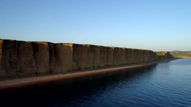 Drone yavaş yavaş kayalıklarla ve beach West Bay Dorset'deki / daki doğru taşır. Altın saat sırasında vurdu. 