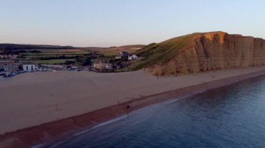 Plaj ve West Bay Dorset kayalıklardan arka planda denize sıfır uçak parçaları yana doğru. Alacakaranlık vurdu 
