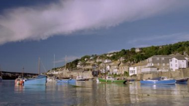 Mousehole Cornwall limana demirleyen renkli balıkçı tekneleri ve dramatik bulut ile statik düşük geniş açı klip