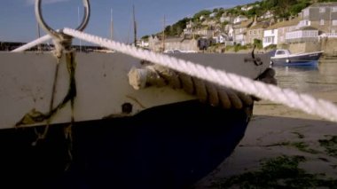 Mousehole Cornwall liman renkli balıkçı tekneleri ile ortaya çıkarmak için küçük tekne arkasında kamera yükselir 
