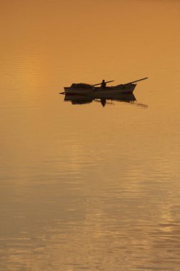 Günbatımı atış Süveyş Kanalı Mısır bir balıkçı arkasında dışarı. Su kanalı'nın derin altın bir renktir